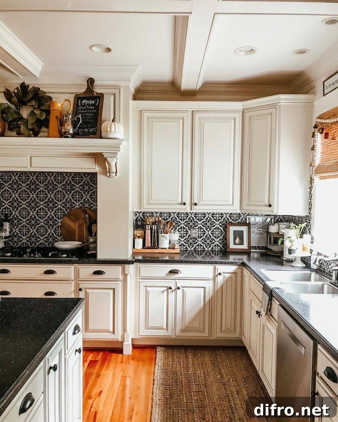 Patterned tiles in kitchen wall with white cupboards.