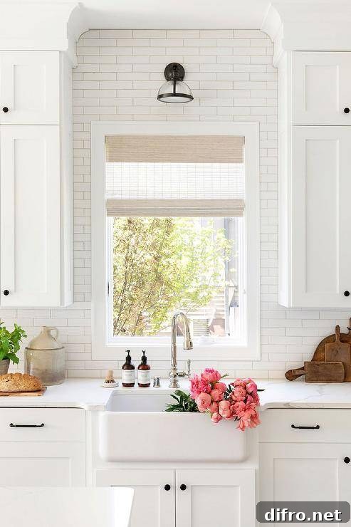 A vintage bronze and rippled glass sconce is fixed to white subway backsplash tiles over a farmhouse kitchen sink matched with a polished nickel gooseneck faucet.
