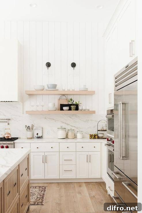 Vertical shiplap walls above white marble backsplash and white quartz countertops.
