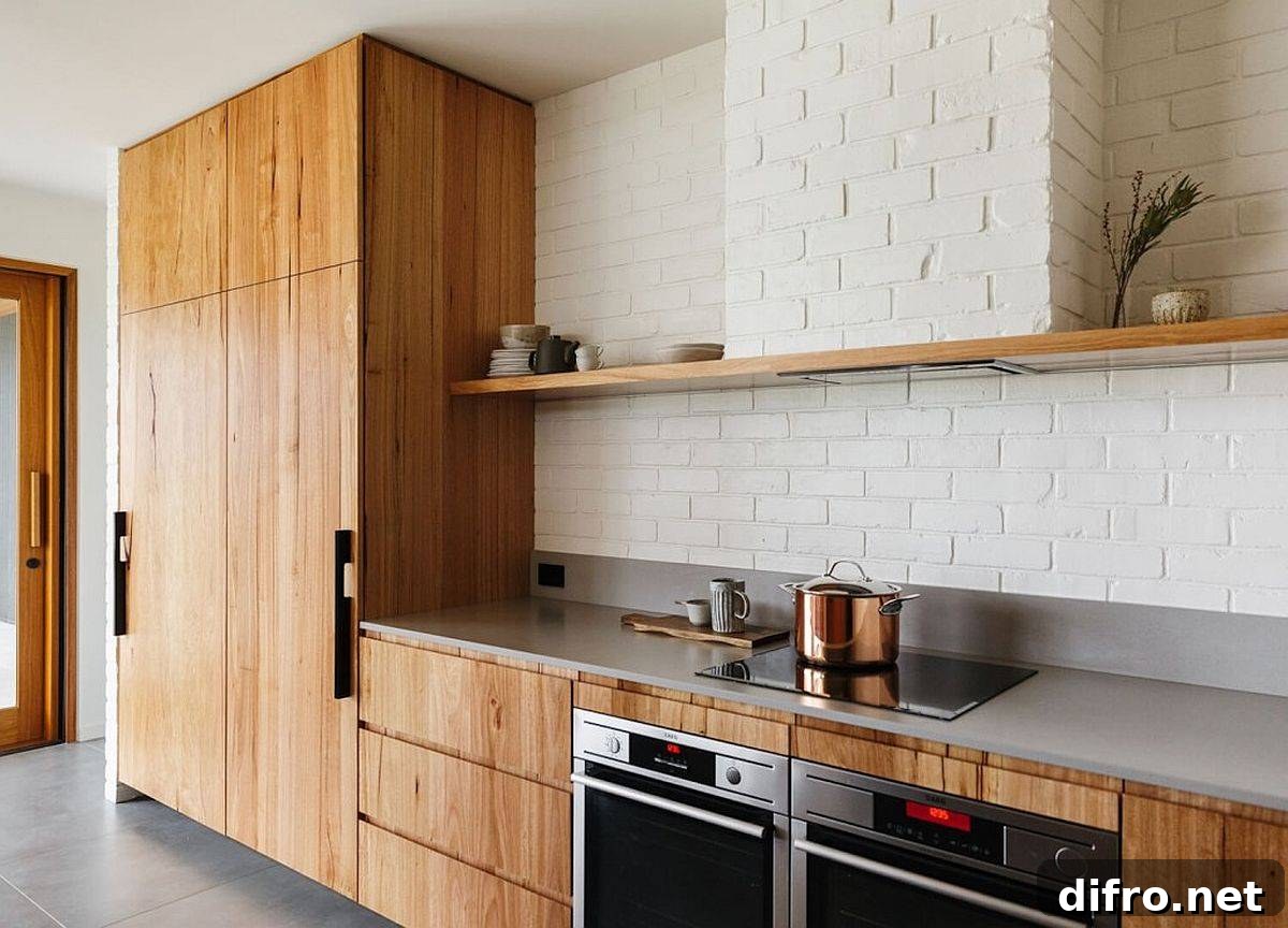 Wooden cabinets for the single-wall kitchen with white-painted brick backsplash