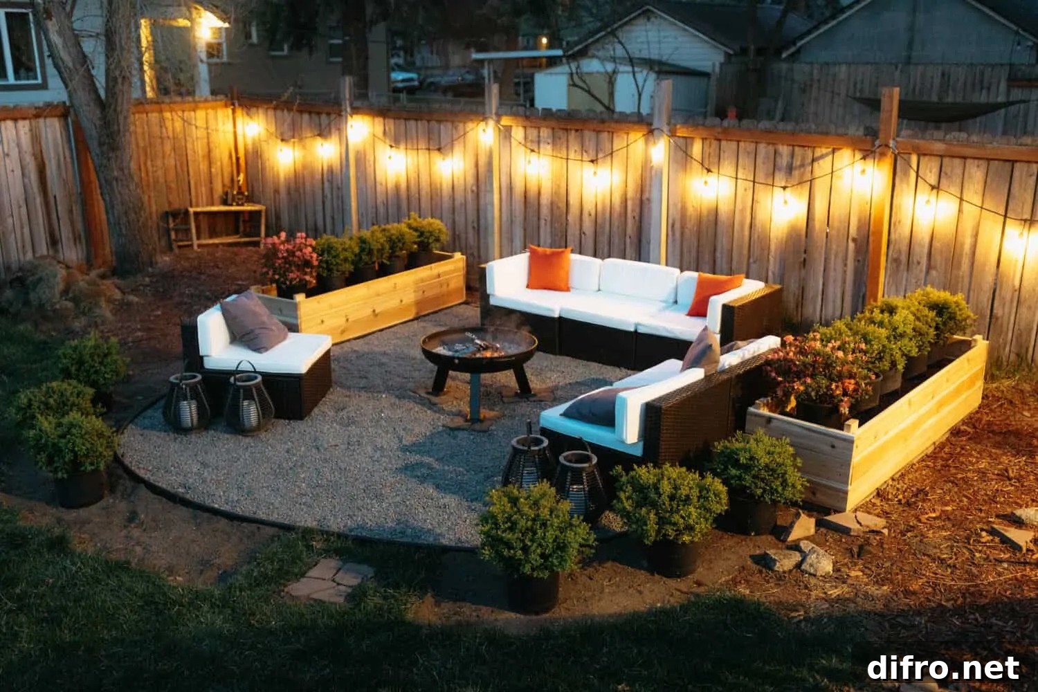 Outdoor firepit surrounded by white sofa with cushions and planters
