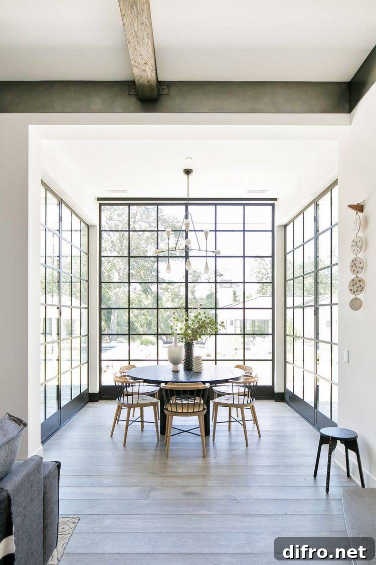 Floor-to-Ceiling Windows to Maximize Natural Light and Space 13 Light shining into a beautiful dining area through floor-to-ceiling windows.
