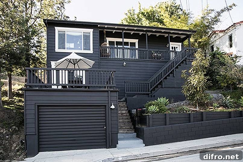 White patio umbrella on the deck of a black house