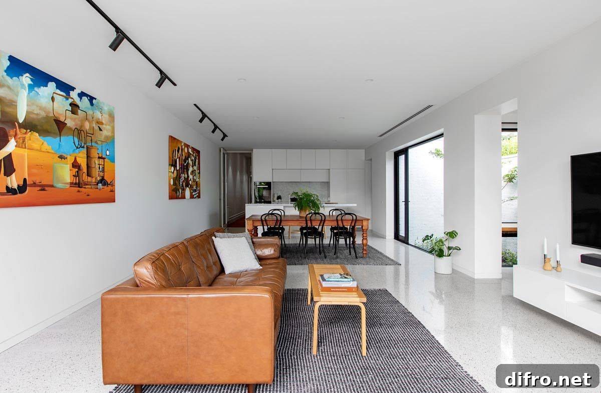 Open plan living area, dining space and kitchen in white with bright wall art and modern decor