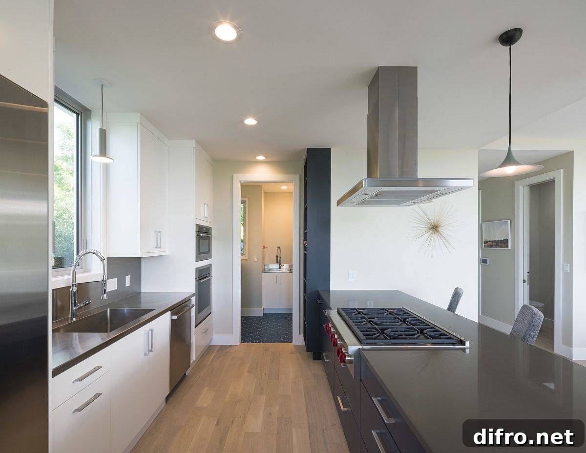 Large central island inside the kitchen along with the breakfast zone stands in contrast to the lighter hues all around it