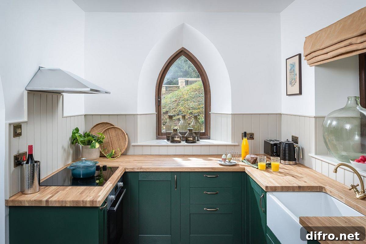 Eclectic kitchen with dark green cabinets and creative window design