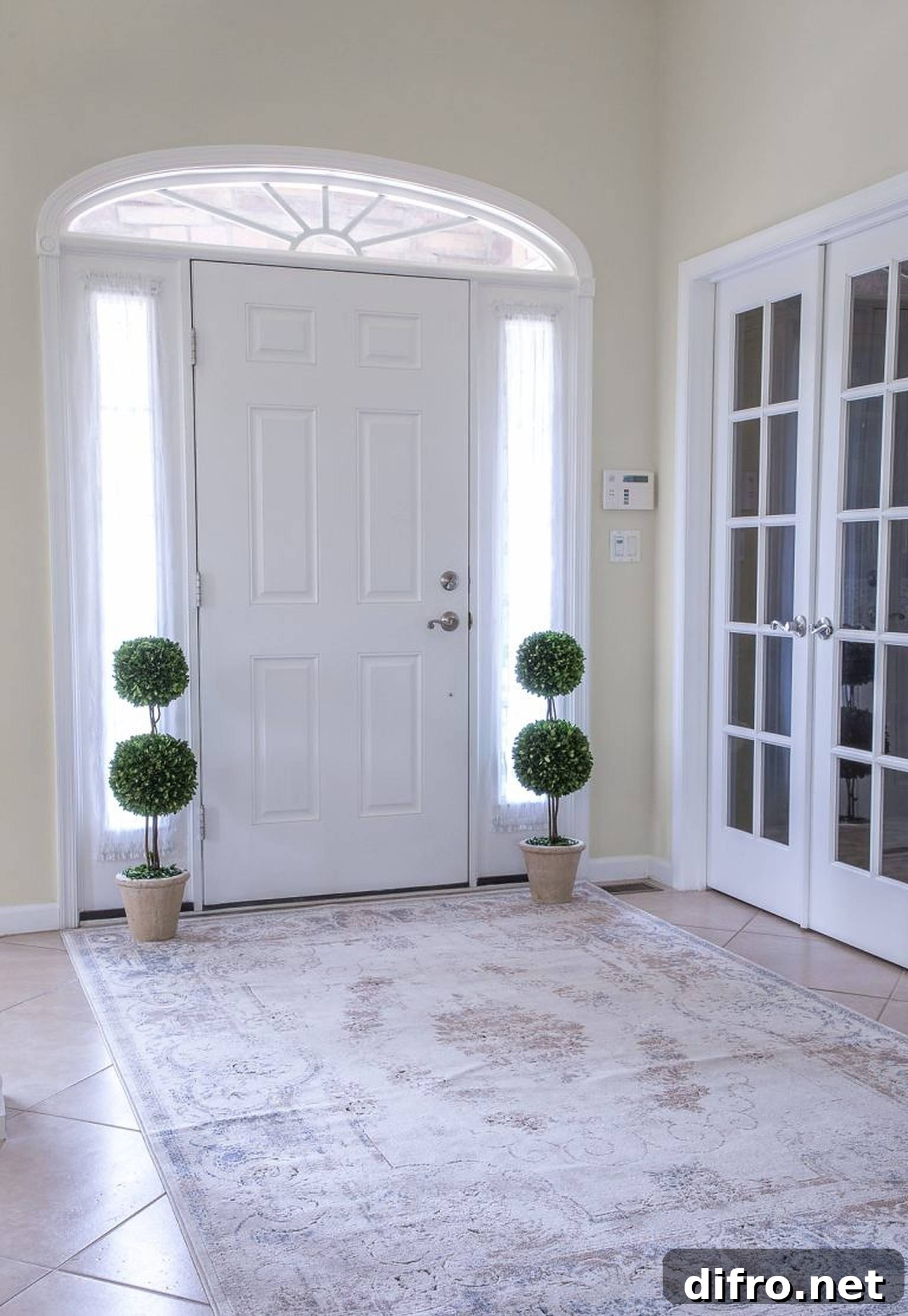 Elegant foyer with sculpted potted plants on each side of the door