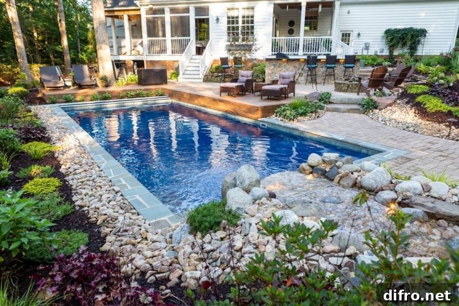 rock garden bordering square inground pool