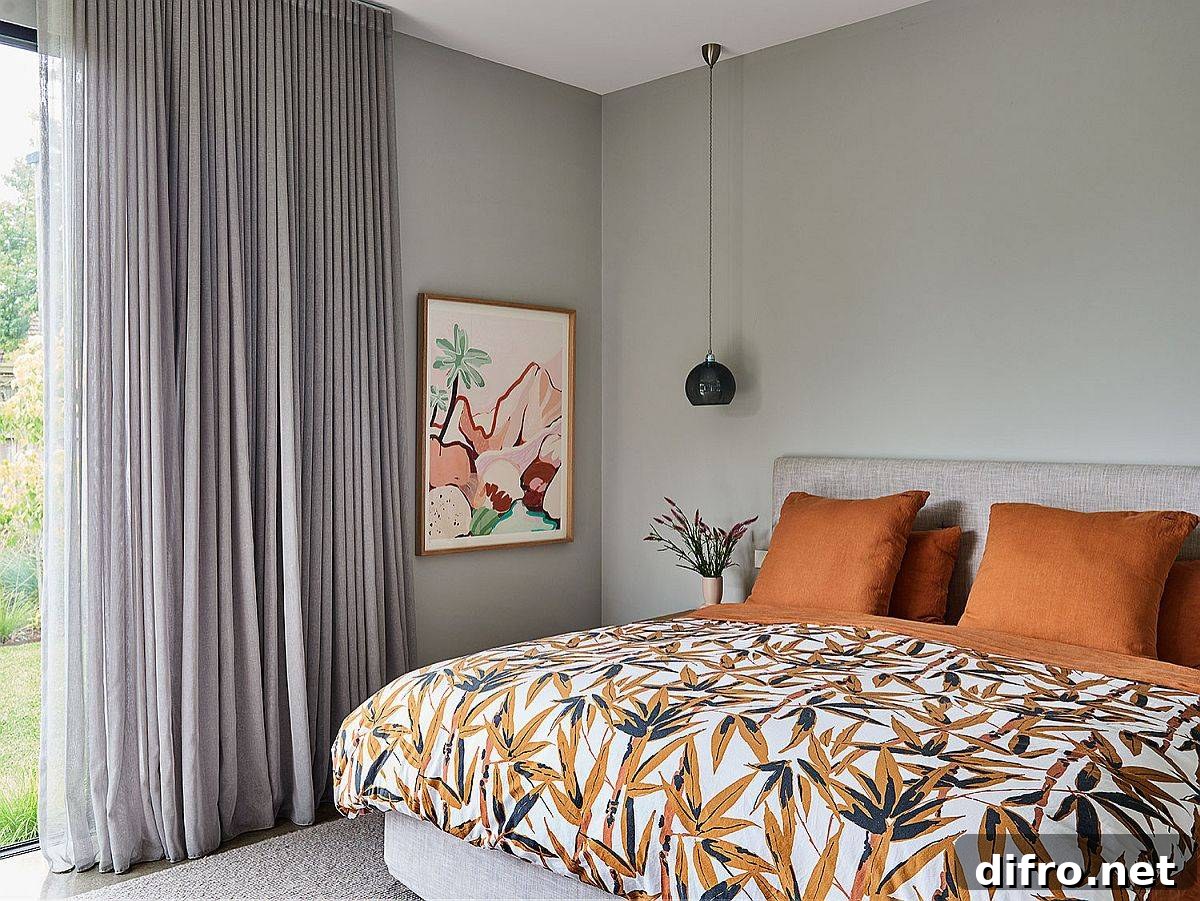 Gray bedroom with orange bedding and pillows