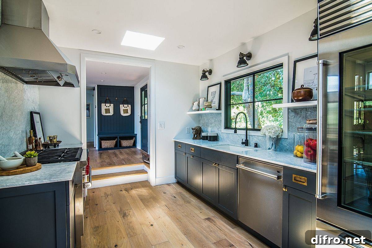 Spacious modern kitchen with deep gray cabinets, marble countertops and sconce task lights above the counter