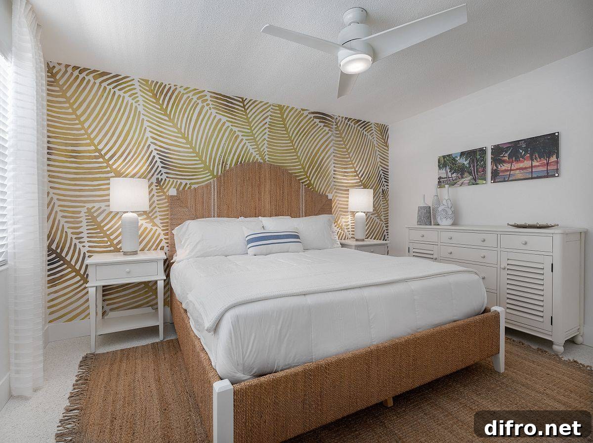Leafy wallpaper behind the bed brings a coastal vibe