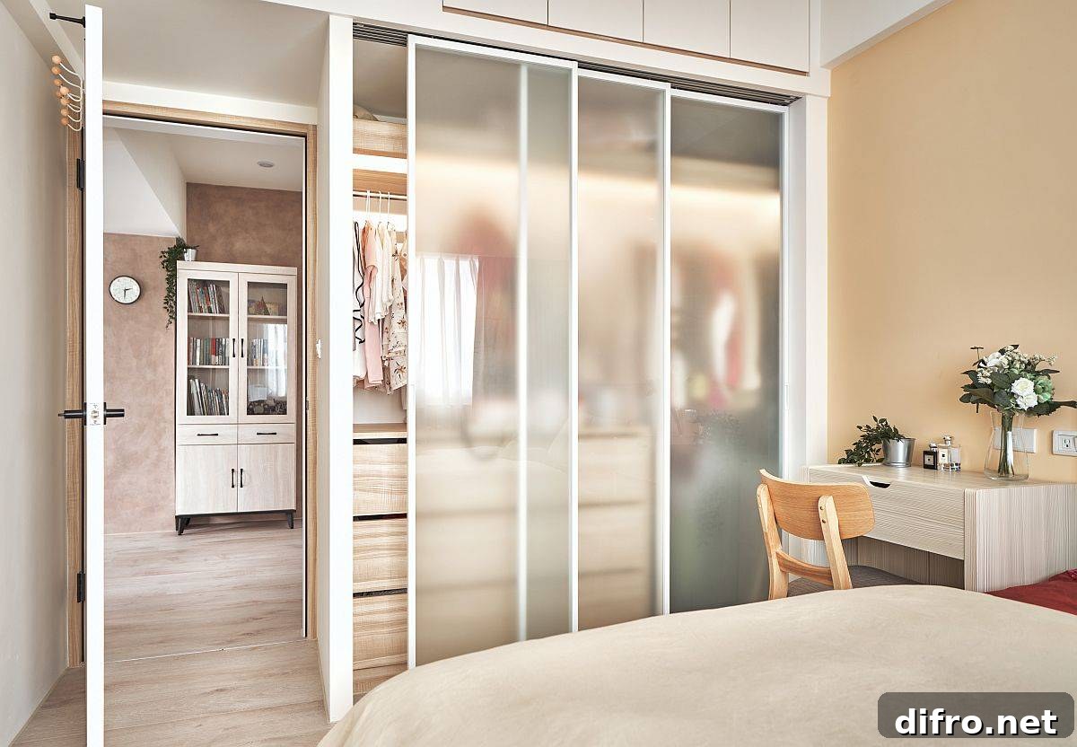 Custom wardrobe with frosted glass doors maximizing visual space in the bedroom