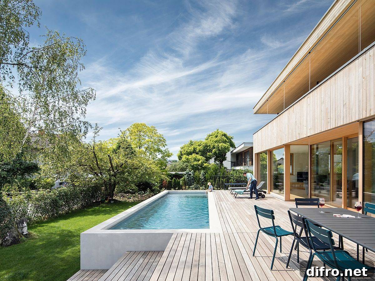 Expansive wooden deck of the home with outdoor dining space and a pool that offers refreshing ambiance
