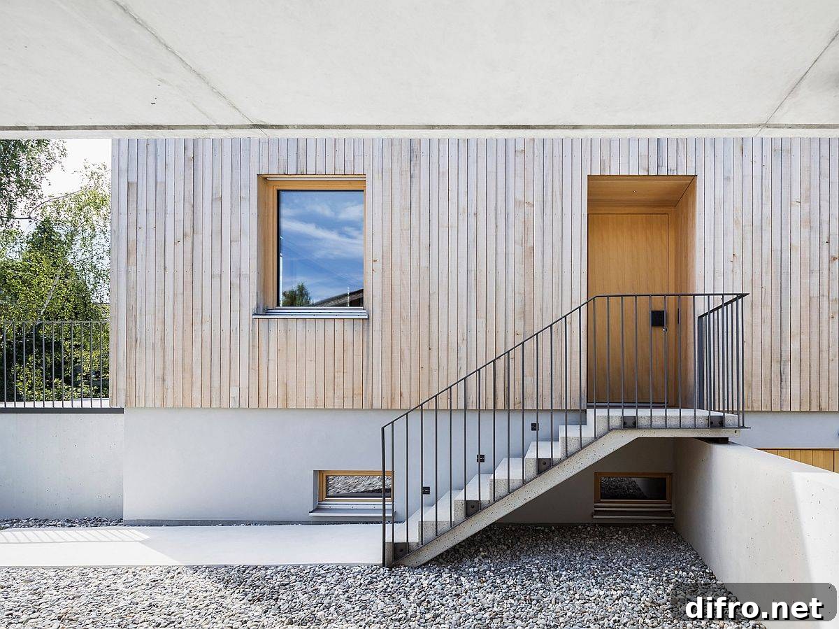 Covered entrance of the home beautifully combines concrete with wood