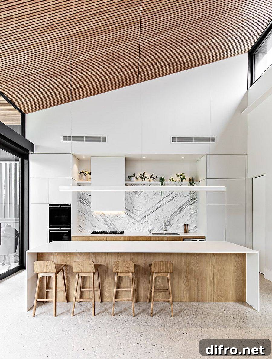 Sloped wooden ceiling and sliding glass doors in a wood and white kitchen