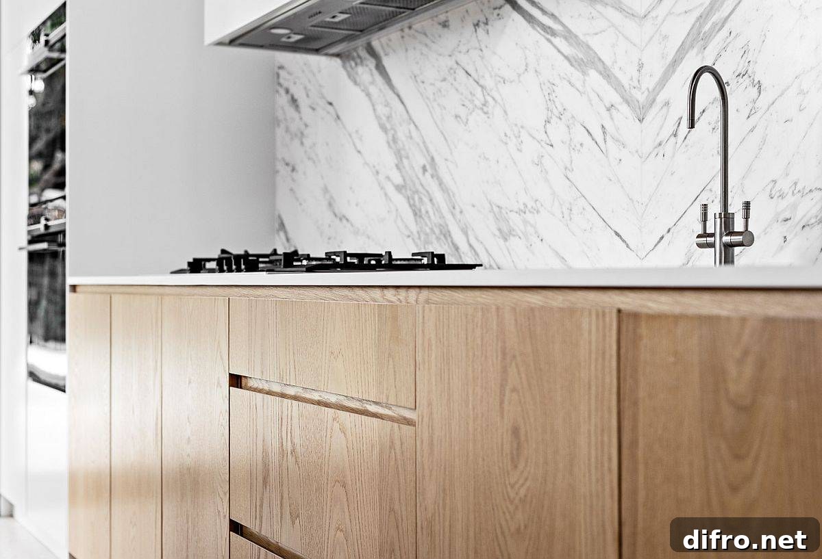 Minimal wooden cabinets complementing marble backsplash