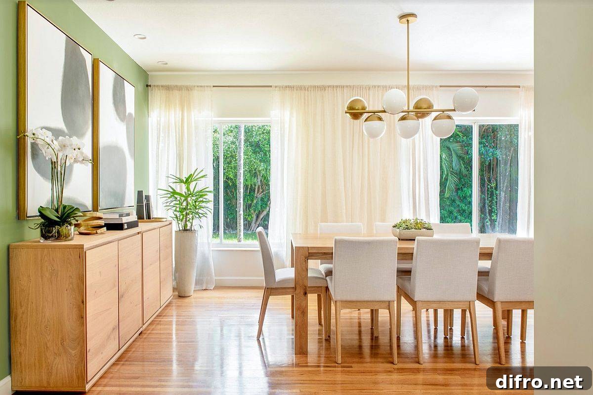 Modern dining room with green accent wall and black and white art