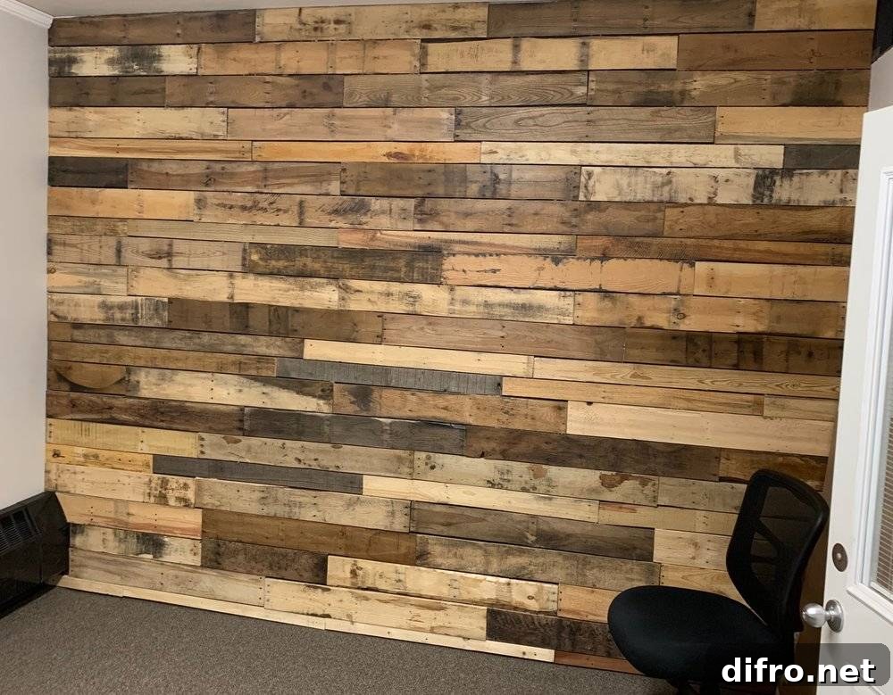 Pallet accent wall and a black office chair.