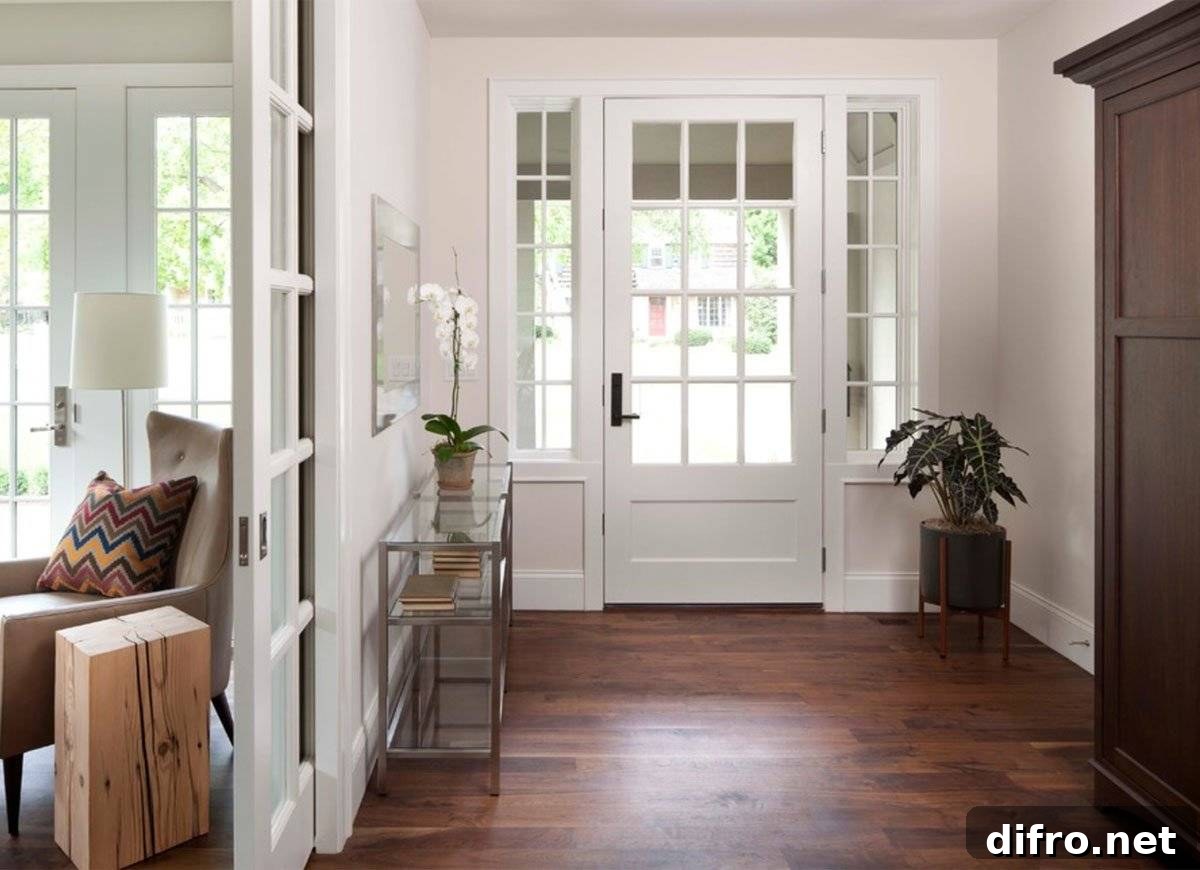 Entryway with a white door and a glass/metal rectangular table with a plant on top.