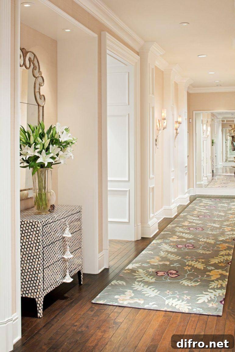 Entryway with a rug runner, featuring a table with mirror and a plant.