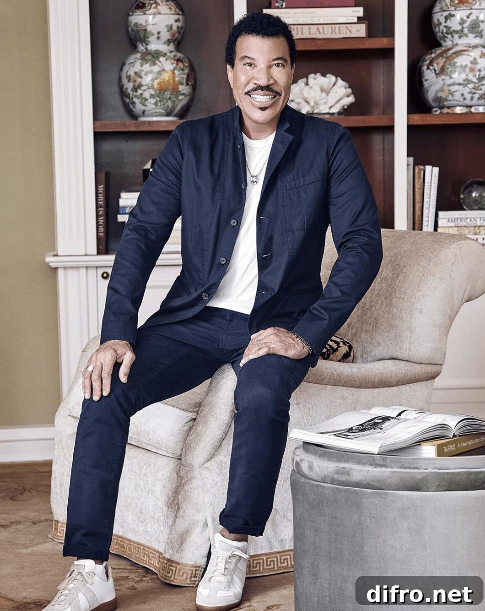 lionel ritchie sitting on a velvet chair in a blue suit