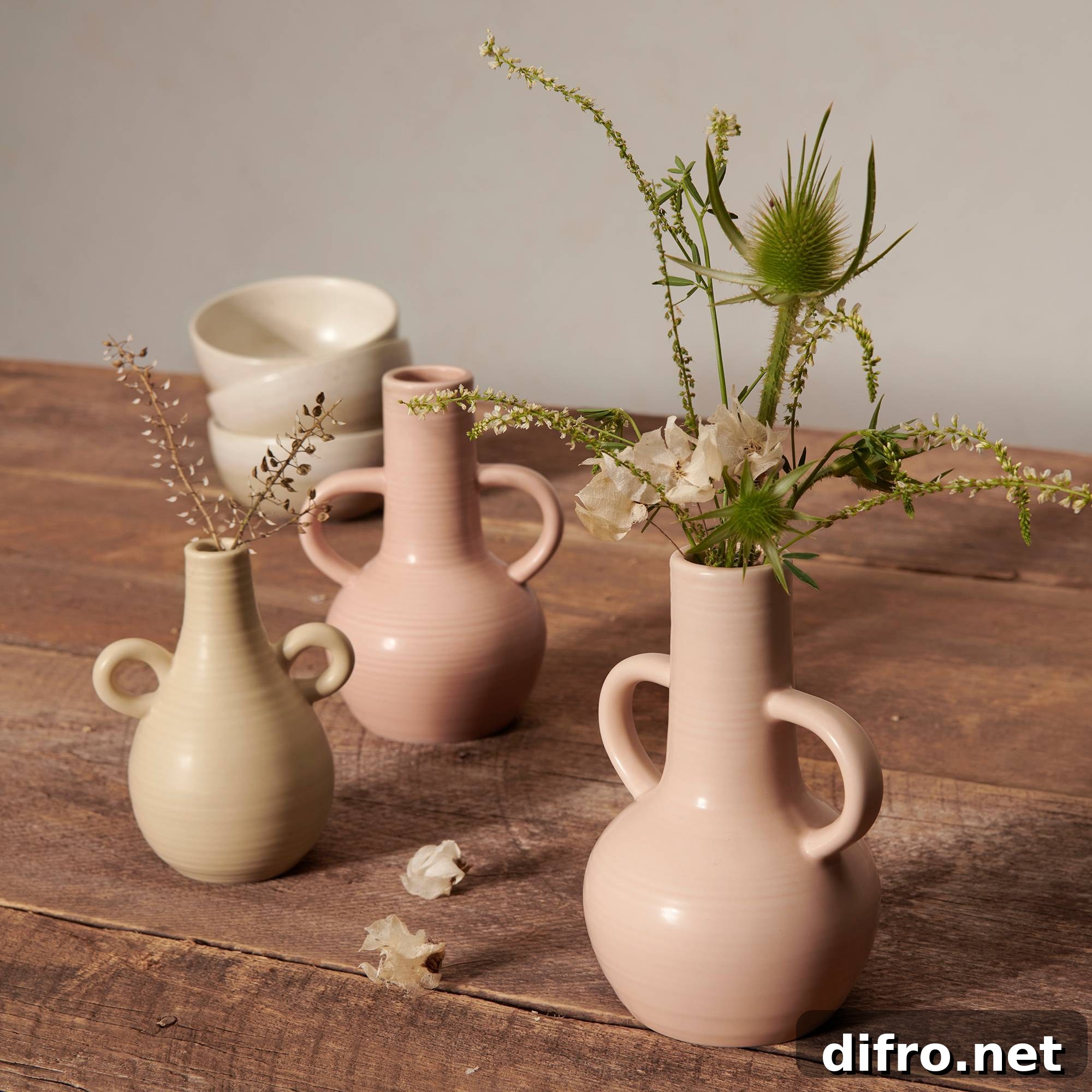 pale pink blush and neutral vases on a wood top table with florals and greenery