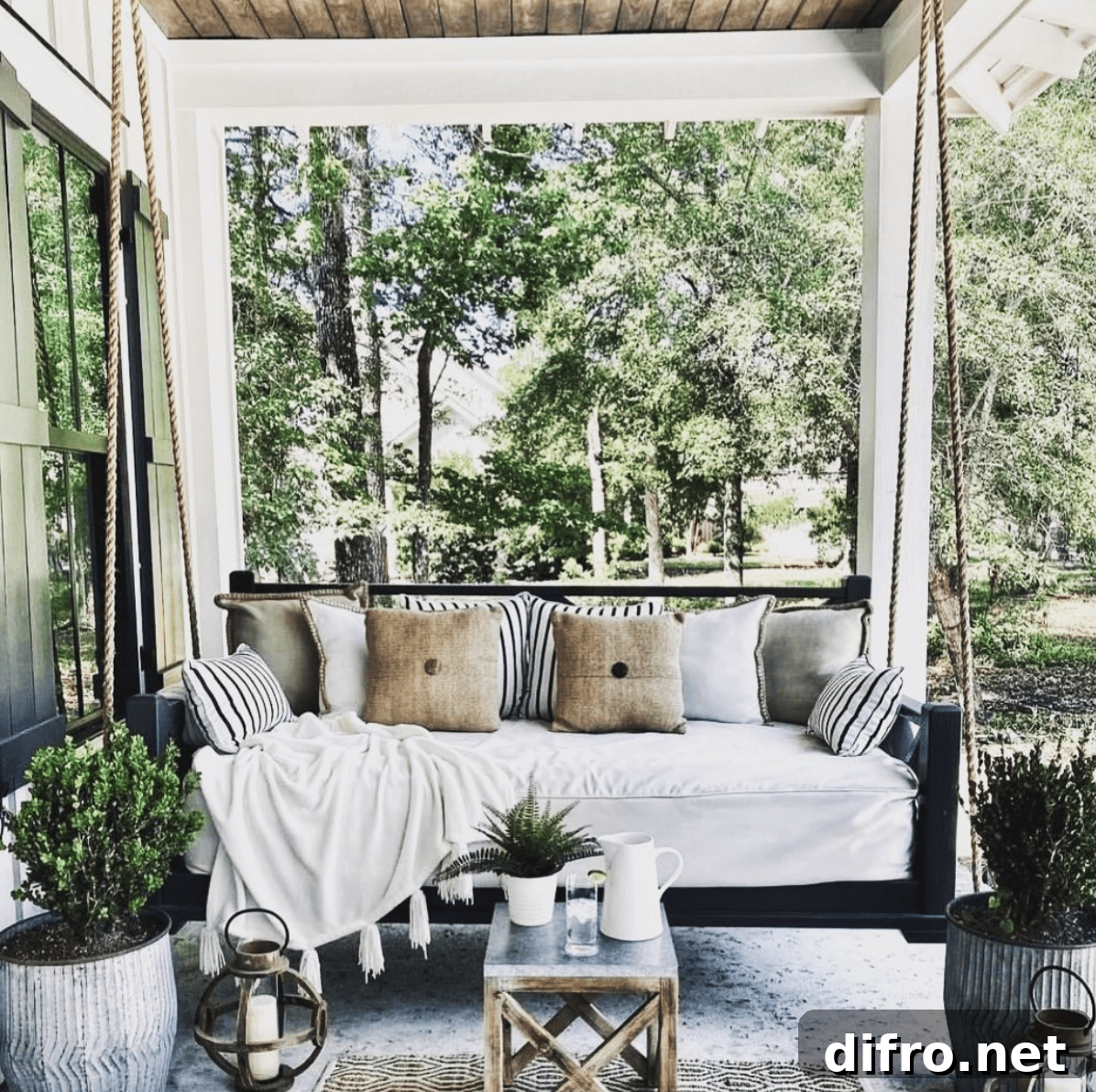 black frame wood porch swing hanging white cushion lantern patio decor
