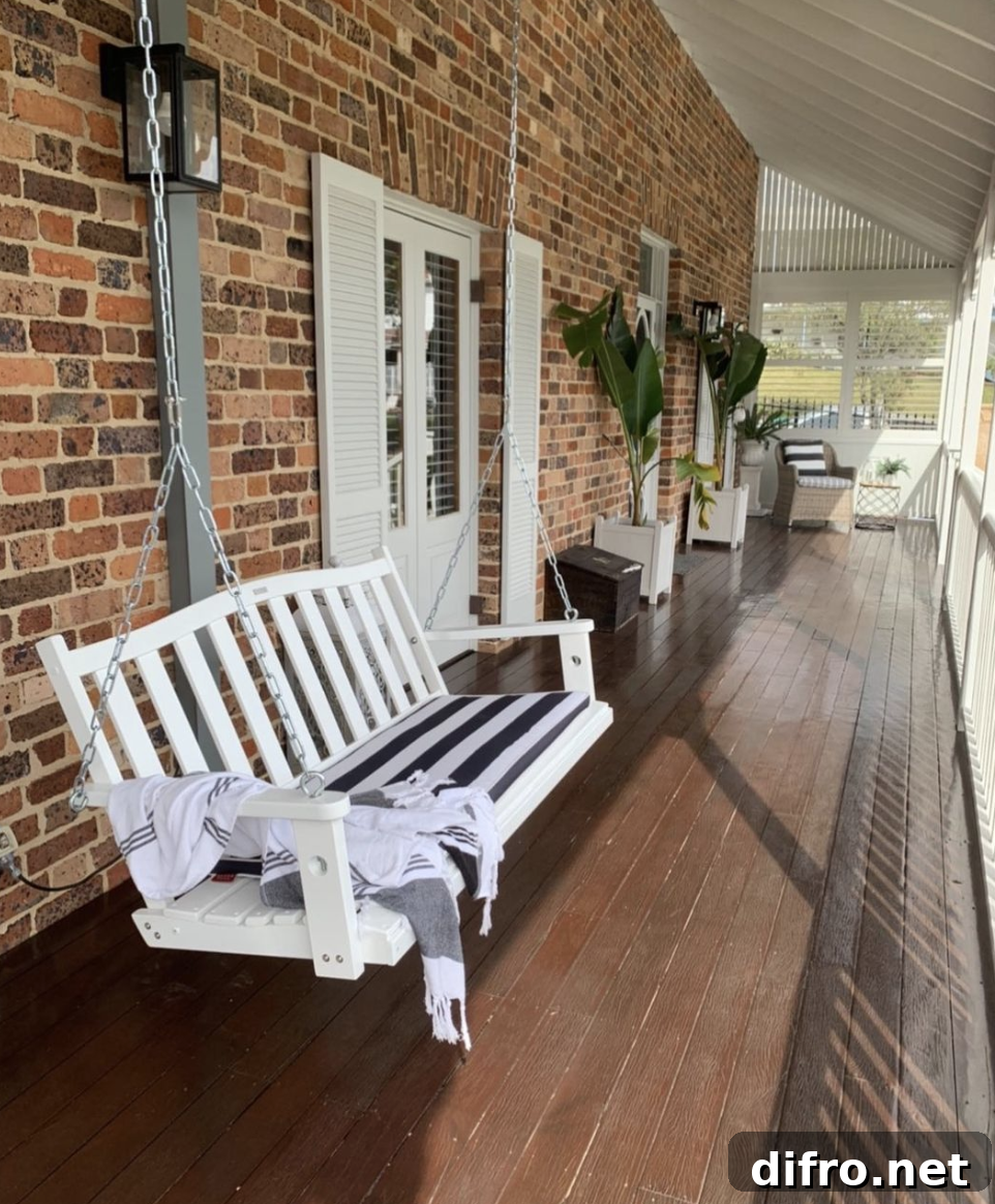 hanging white porch swing brick porch white shutters wood plank floor outside
