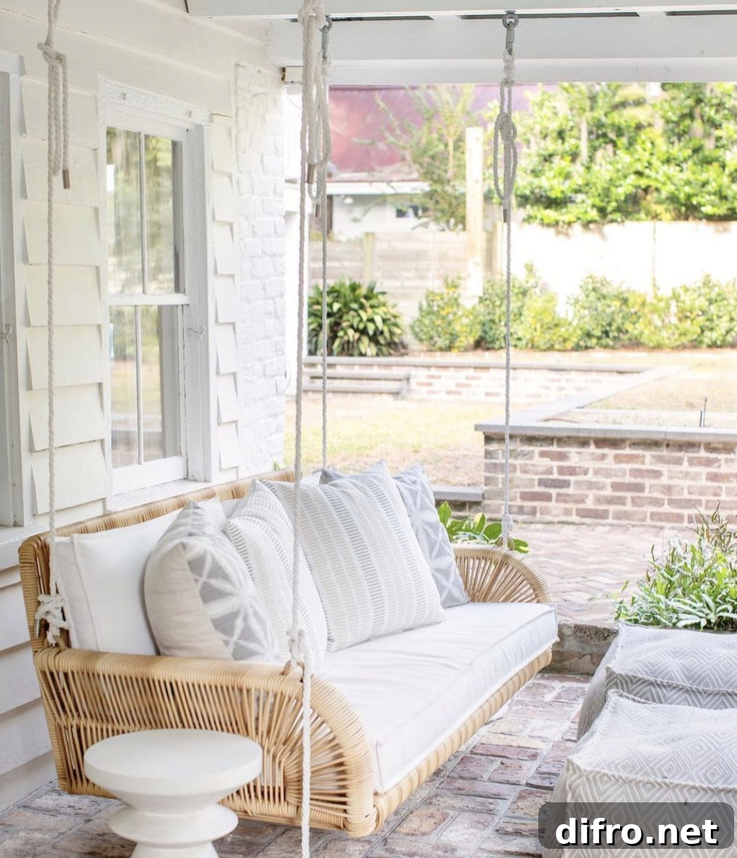 natural wicker patio porch swing white cushions pillows white brick