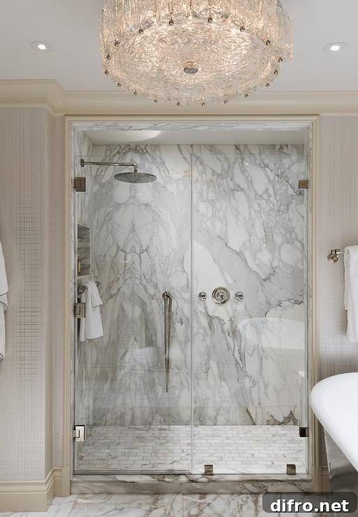 Marble subway tile floor in a walk in shower mixed with a marble slab shower wall adds a luxurious appeal to a master bathroom finished with a glass-enclosed door and nickel hardware