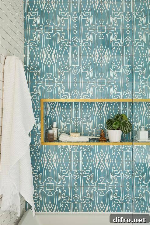A blue mosaic tiled niche lined with brass trim is framed by blue mosaic accent tiles