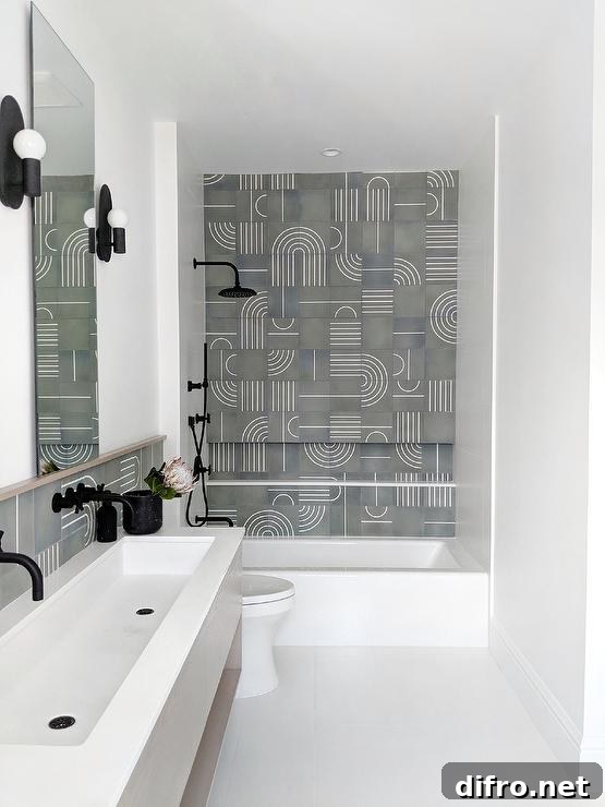 A drop in bathtub matched with a matte black shower kit accented with white and gray modern mosaic wall tiles