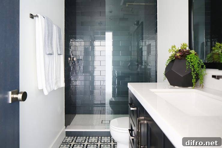 black and blue geometric floor tiles and a walk-in shower finished with glossy blue stacked wall tiles