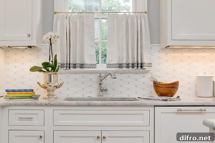 Window dressed in white cafe curtains over a sink in a white kitchen with gray backsplash