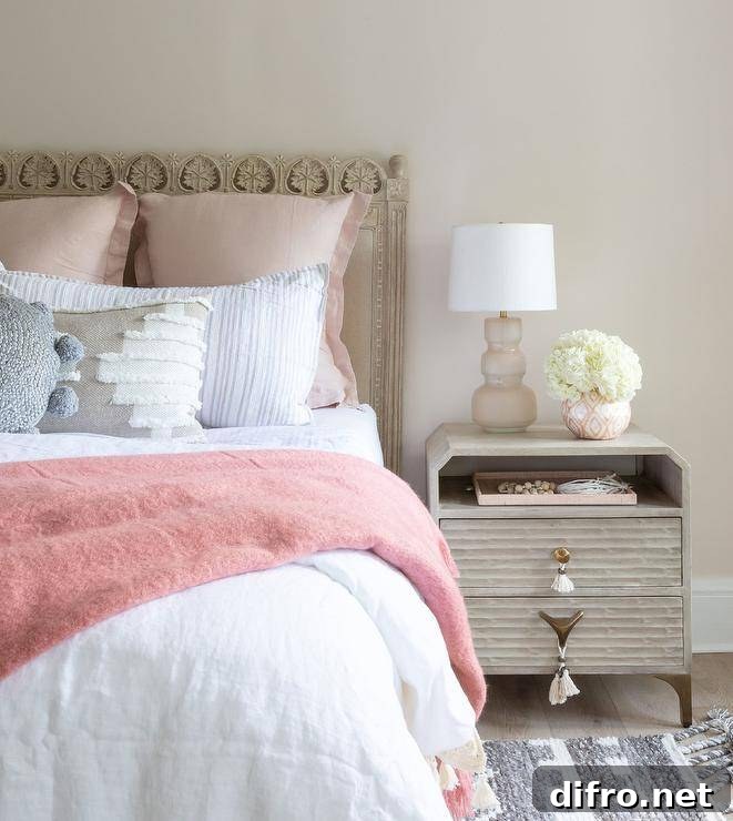 blush pink and beige bedroom with carved wood bed and gray rug