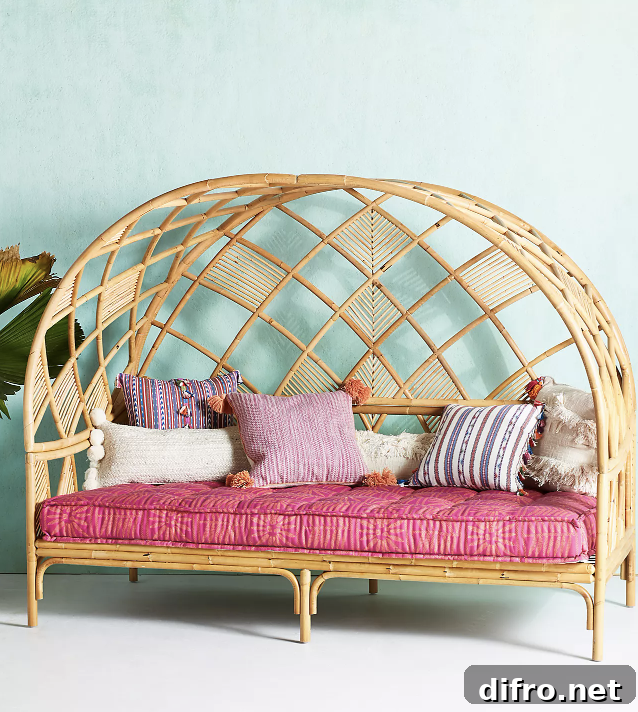 Rattan daybed with hot-pink cushion and tassel pillows