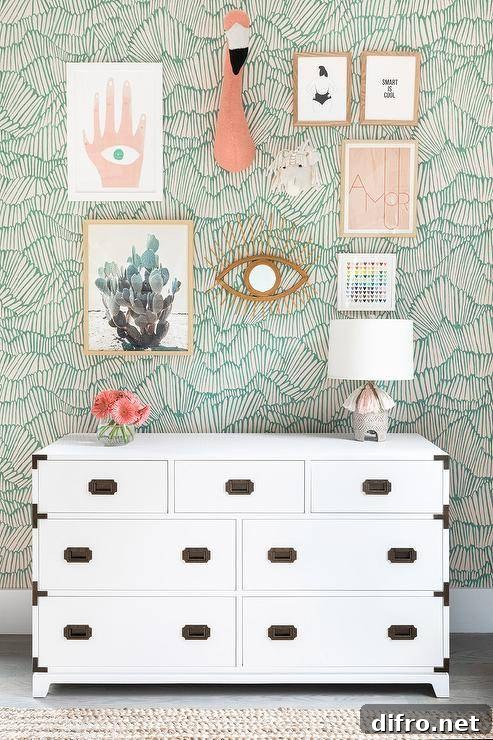 gallery wall on green pattern wallpaper white chest dresser flamingo head hanging on wall
