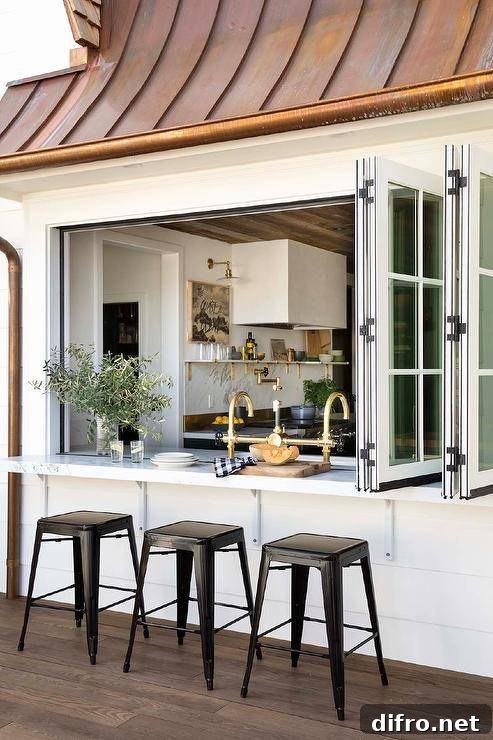 A folding kitchen pass-through window opens to a patio bar seating four black Tolix stools.