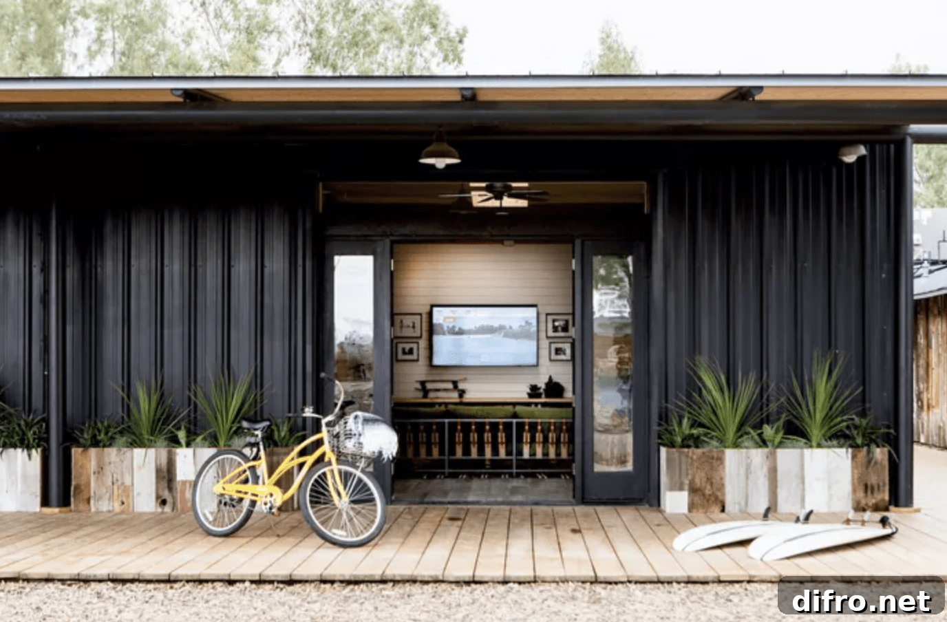 Black siding house with open doors and bike on front porch