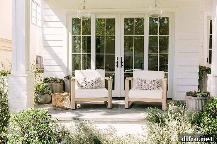 Styled covered porch with hand blown glass lanterns and teak chairs