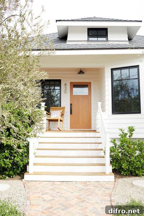 Craftsman style bungalow with vertical house numbers brings a modern touch to the porch along with a wood rocking chair.