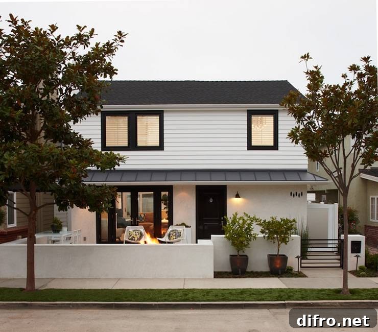 White and black home exterior design with semi-covered porch and black door and window moldings.