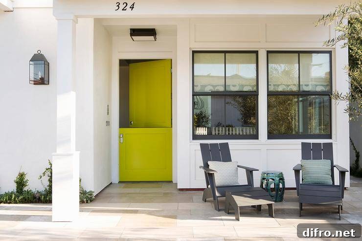 A stunning white home is accented with a neon yellow Dutch front door finished with a modern door knob.