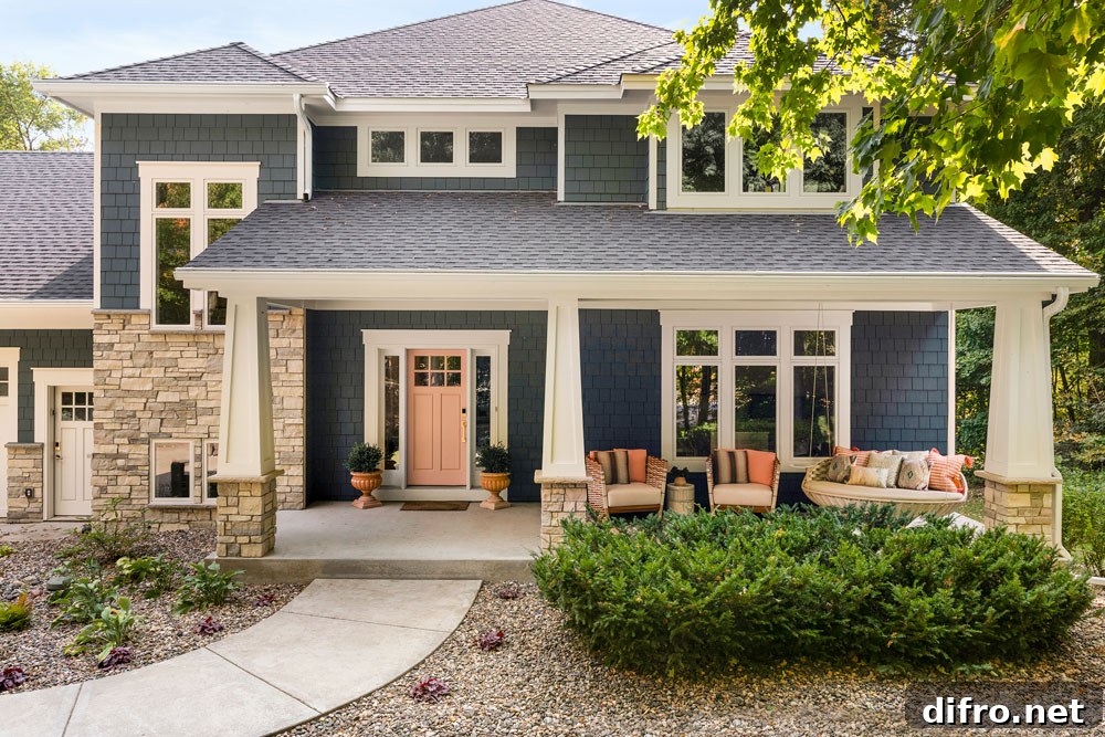 Blue siding house front with pink door and porch furniture