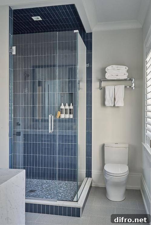 43 Walk-In Shower Ideas to Transform Your Bathroom 15 blue vertical subway tile walk in shower with all glass doors toilet with shelf over top and white towels