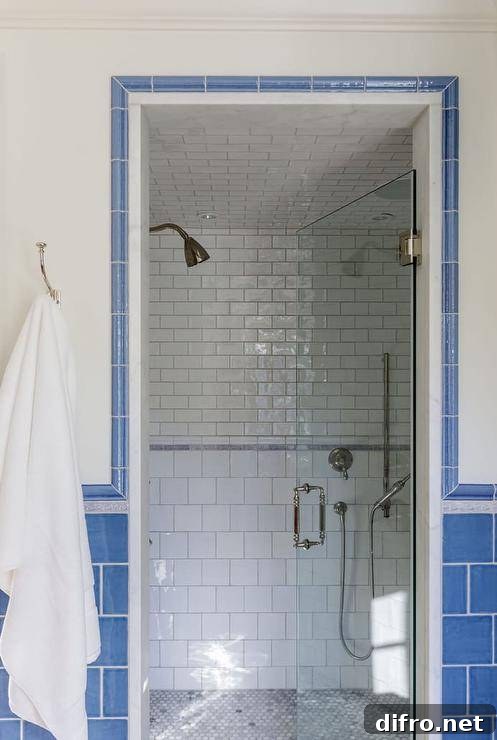 43 Walk-In Shower Ideas to Transform Your Bathroom 23 Blue subway tile framed walk in shower with white subway tile inside white towel hanging on wall