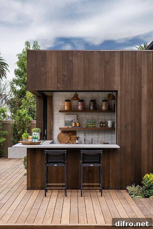 Black stools sit on a brown plank deck at an l-shaped brown plank wet bar accented with concrete countertops.