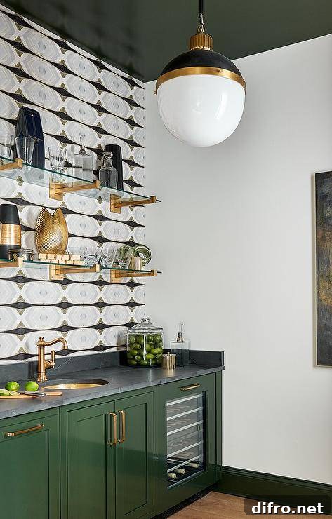 Glossy green lacquered cabinets with brass shelves and a brass sink positioned beneath an antique brass faucet.