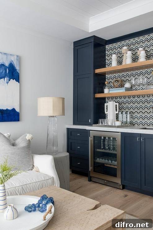 Blue family room wet bar features blue shaker cabinets and a marble countertop with a mini beverage fridge.