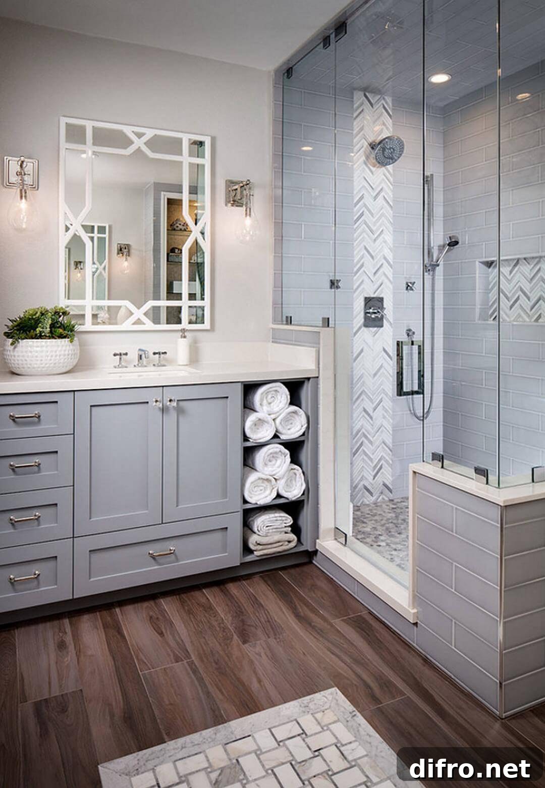 grey bathroom cabinetry with hardwood floor walk in shower folded white towels in open cabinetry